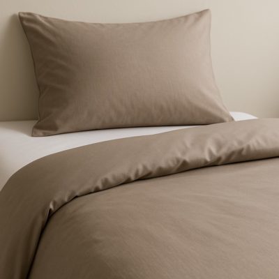Bed met taupekleurig dekbedovertrek van Egyptisch katoen en witte percale kussenslopen