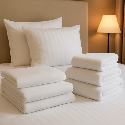 Hotelbed met witte lakens, kussens en handdoeken zorgvuldig opgestapeld