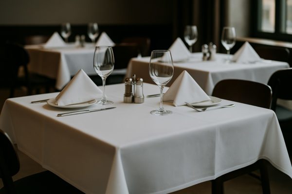 Strak gedekte horecatafel met fris wit tafellinnen en servetten, symbool voor professionele linnenverhuur