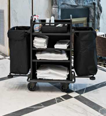 Netjes gestapeld hotel linnen op een housekeepingkar, klaar voor uitlevering.
