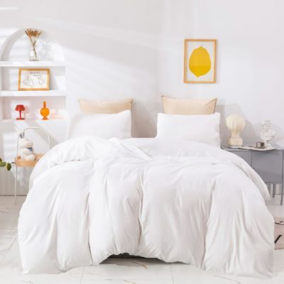 Gestapelde witte hoteldekbedden in een nette, professionele presentatie.