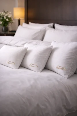 Kussens hotel met drie hardheden op een opgemaakt bed voor verschillende slaaphoudingen